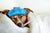Hund liegt mit Fieberthermometer unter einer Decke. Hund ist krank.